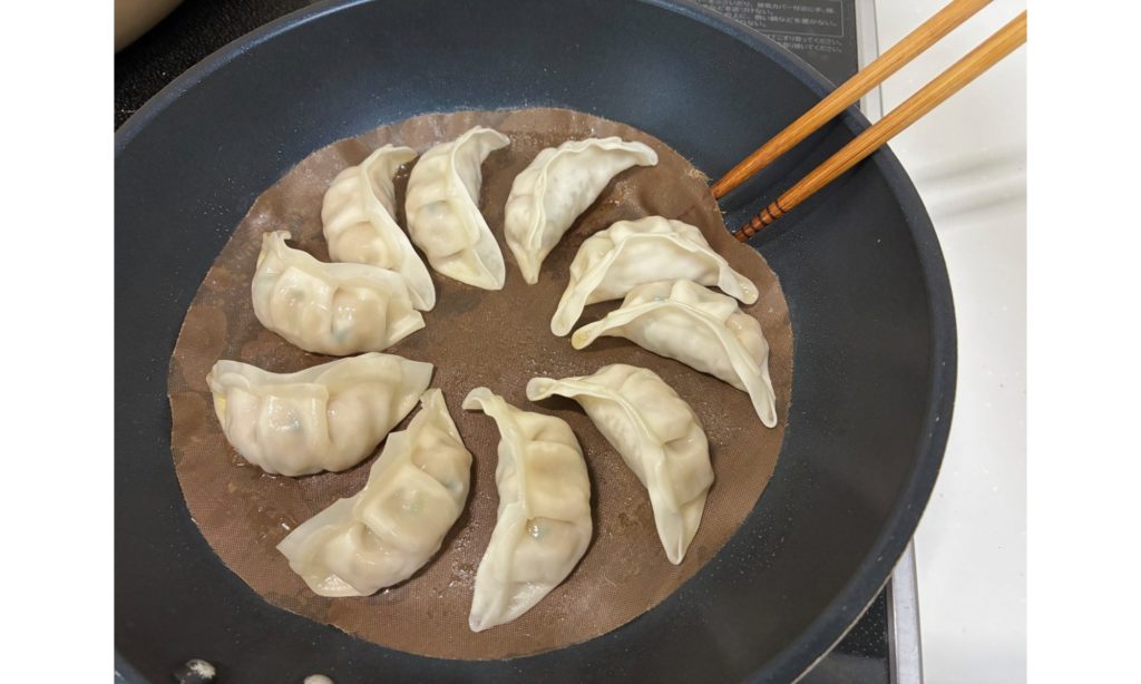 クッキングシートを使った餃子の焼き方ステップ　菜箸で間をはがす